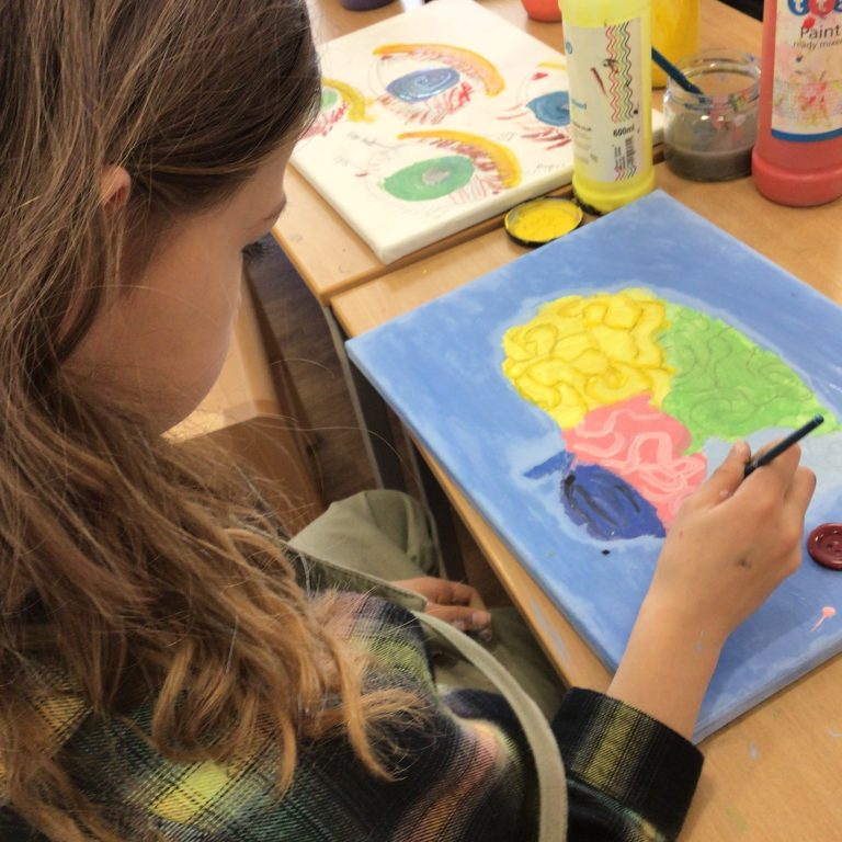 student painting a brain