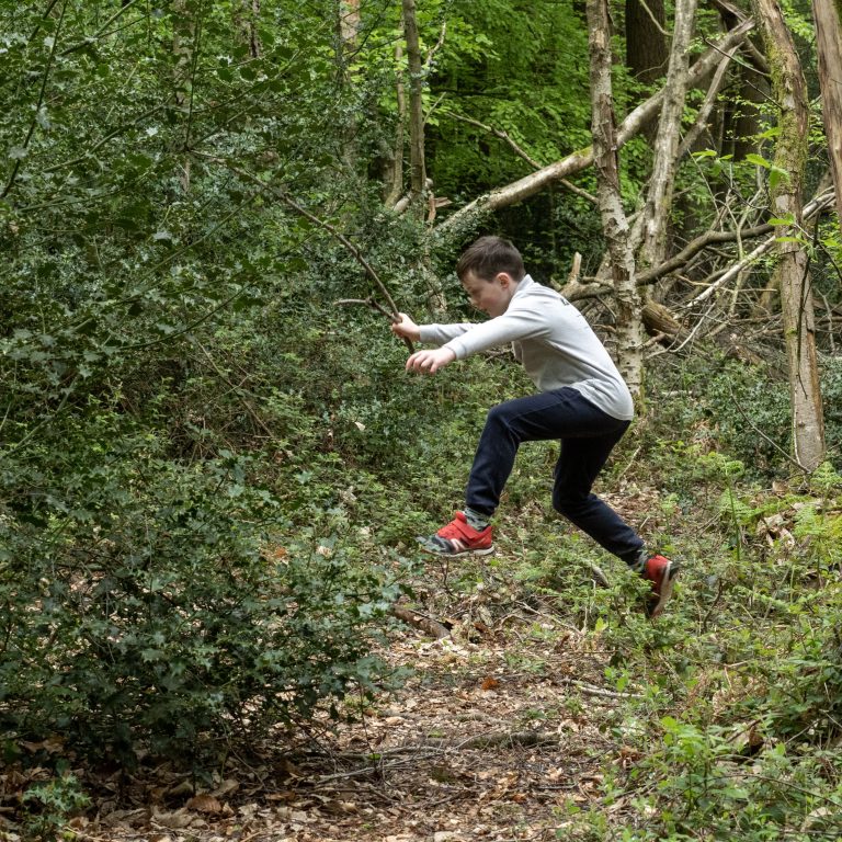 student jumping in the forest